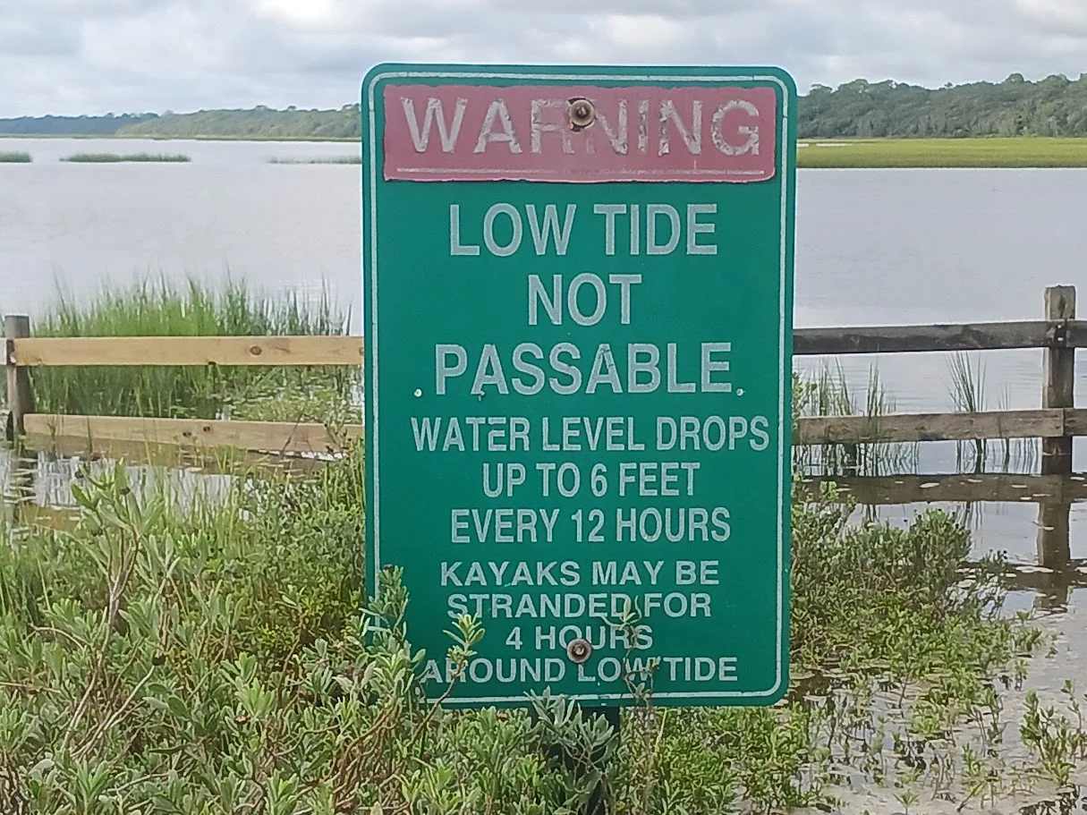 tide caution sign at boat ramp along guana river, ponte vedra